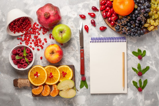 Top view fresh fruits oranges raspberries and pomegranates on white surface fruit fresh mellow juice tropical exotic