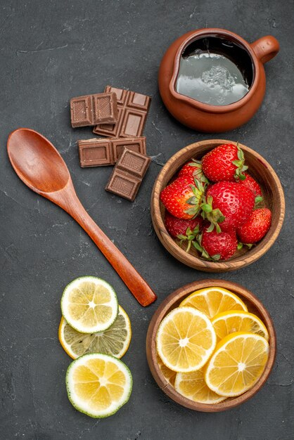 Top view fresh fruits strawberries and lemons on a gray surface