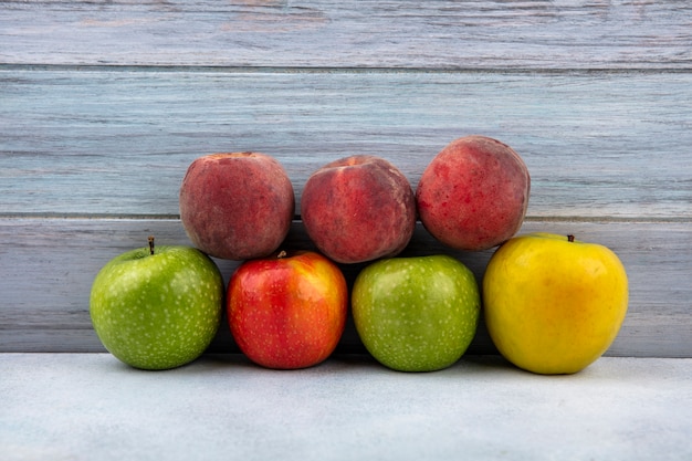 Vista dall'alto di frutta fresca come mele colorate e pesche su legno