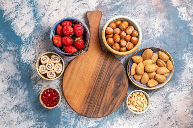 Top view of fresh fruits with nuts on blue surface