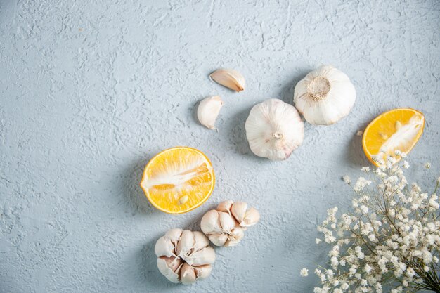 Top view fresh garlics with lemon on light background food plant vegetable pepper sour seasoning