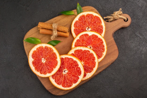 Free photo top view fresh grapefruit slices on a dark background