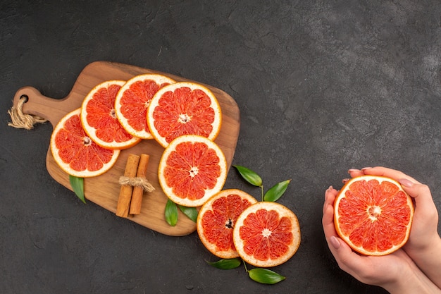 Free photo top view fresh grapefruit slices on dark background