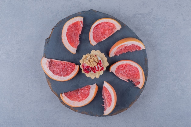 Top view of fresh grapefruit slices on wooden board