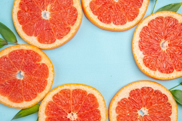 Free photo top view fresh grapefruits fruit slices on a blue background