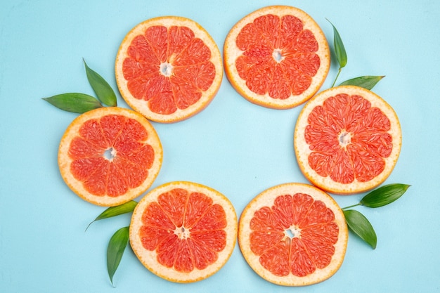 Top view fresh grapefruits fruit slices on blue background