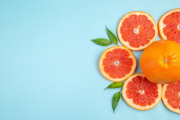 Top view fresh grapefruits fruit slices on blue background