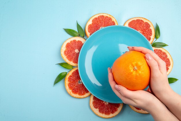 Top view fresh grapefruits fruit slices on blue background