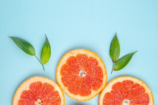 Top view fresh grapefruits fruit slices on blue background