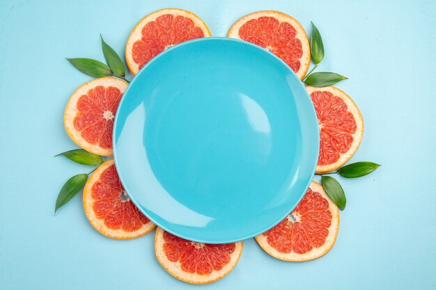 Top view fresh grapefruits fruit slices on blue background