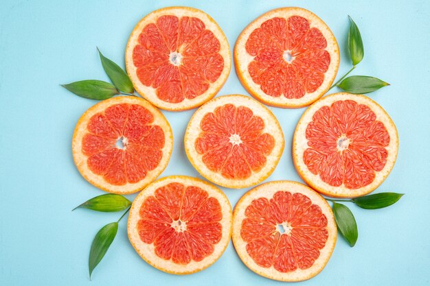 Top view fresh grapefruits fruit slices on blue background