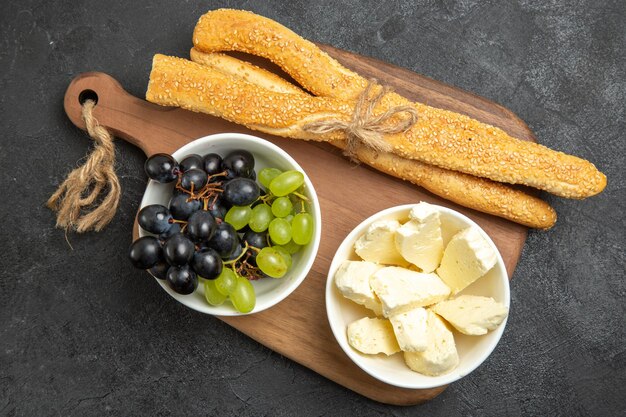 暗い表面にチーズとパンを添えた新鮮なブドウの上面図フルーツまろやかな熟した木ビタミンフードミルク