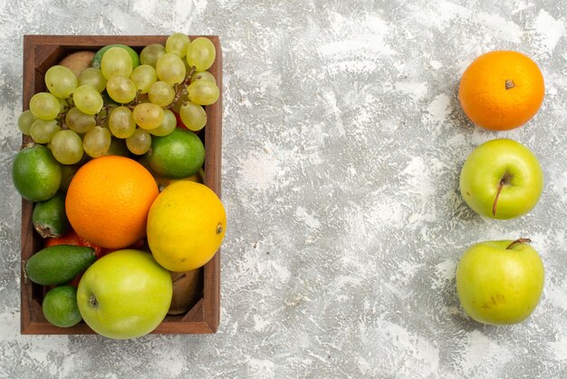 上面図新鮮なブドウとフェイジョアのリンゴとみかんを背景にフルーツまろやかで熟した新鮮なエキゾチックな柑橘類