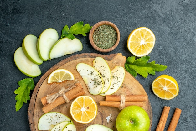 Top view fresh green apple cinnamon sticks apple and lemon slices on wood board