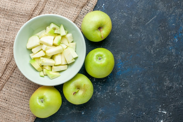 top view of fresh green apples mellow and juicy with sliced apple inside plate on dark-blue desk, fruit fresh food health vitamine