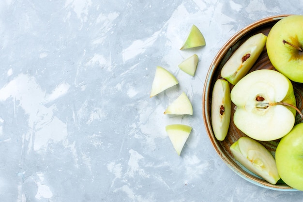 Free photo top view fresh green apples sliced and whole fruits on light-white desk