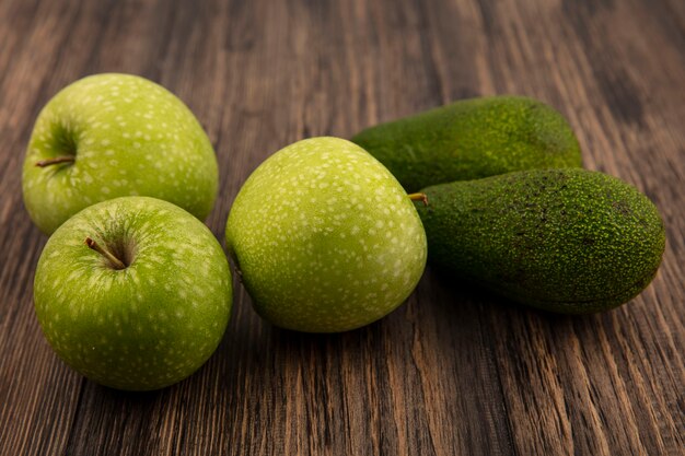 Top view of fresh green apples with avocados isolated on a wooden wall