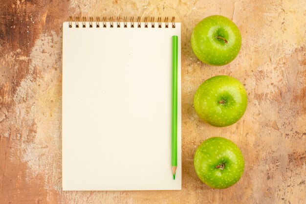 Top view fresh green apples with notepad