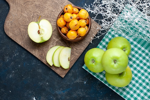 Вид сверху на свежие зеленые яблоки с черешней на темном столе, свежие спелые фрукты