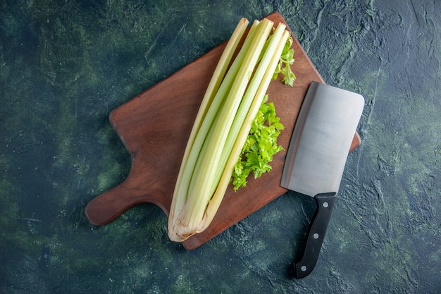 Foto gratuita vista dall'alto di sedano verde fresco con grande coltello su sfondo blu scuro insalata salute dieta cibo pasto foto a colori