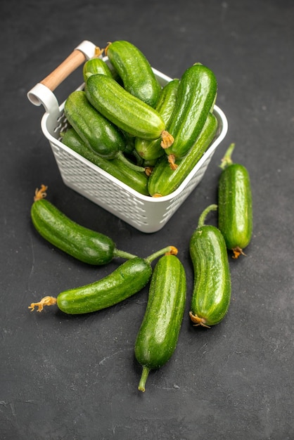 Top view fresh green cucumbers inside basket on a dark background