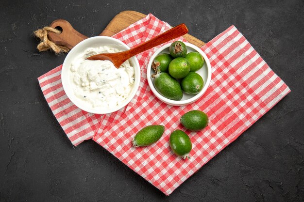 어두운 표면에 크림과 함께 상위 뷰 신선한 녹색 feijoa 과일 이국적인 건강 부드러운