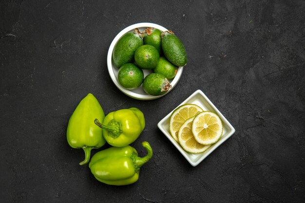 어두운 표면 과일 야채 감귤 부드러운 식물 나무에 레몬 조각과 녹색 벨 후추와 상위 뷰 신선한 녹색 feijoa