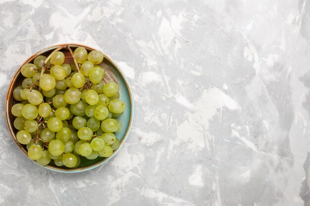 Top view fresh green grapes inside  on white surface