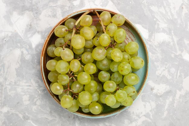 Top view fresh green grapes inside  on white surface