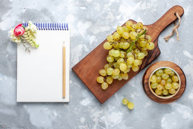 top view of fresh green grapes mellow juicy along with notepad on light, fruit mellow juice fresh