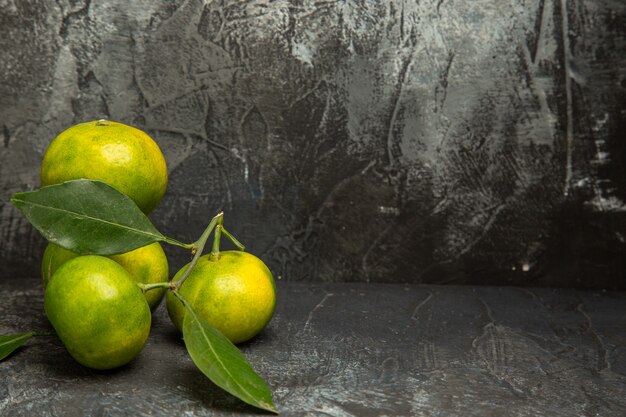 Free photo top view of fresh green mandarins with leaves on the right side of gray background footage