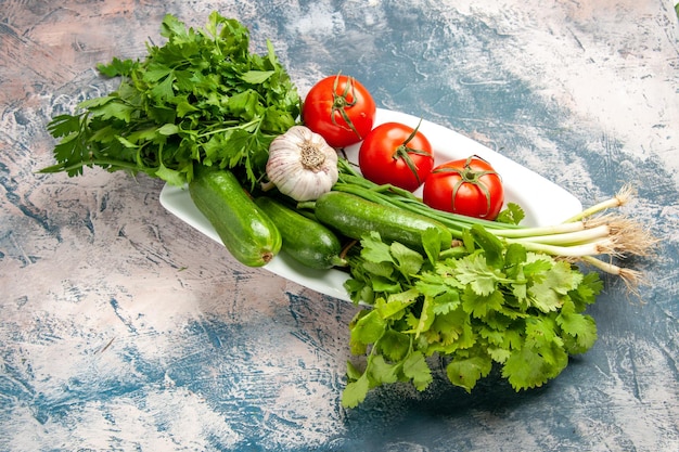 Top view fresh green onion with tomatoes and greens on light-blue background