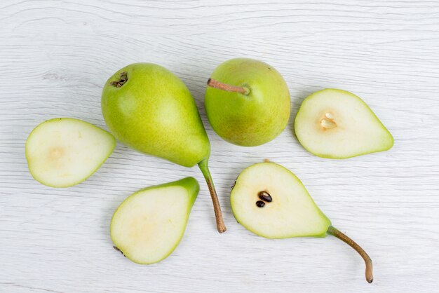 A top view fresh green pears sliced and whole on the white background  fruit color