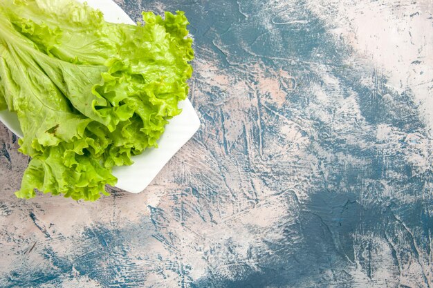 Top view fresh green salad on light-blue background