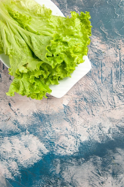 Top view fresh green salad on light-blue background