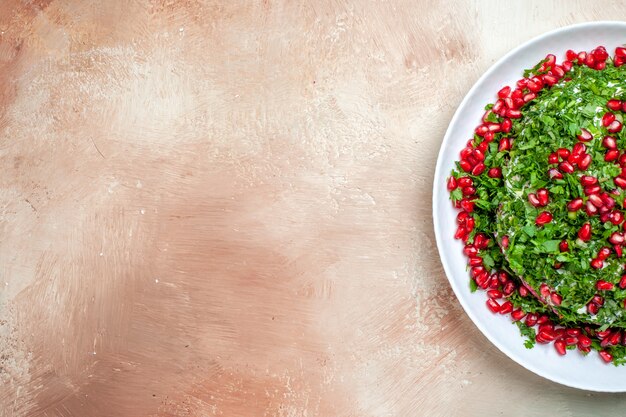 Top view fresh greens with peeled pomegranates on light desk fruit green color