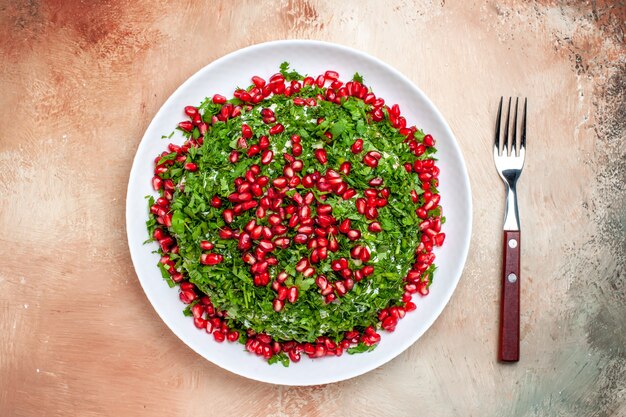 Top view fresh greens with peeled pomegranates on light table fruit color green