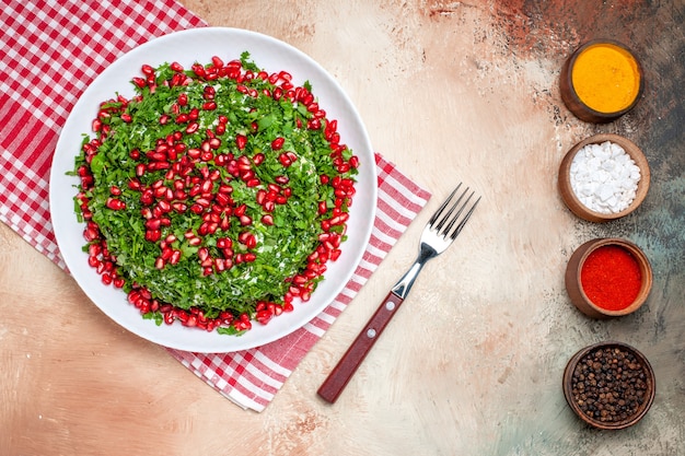 Top view fresh greens with peeled pomegranates on light table fruit greens meal