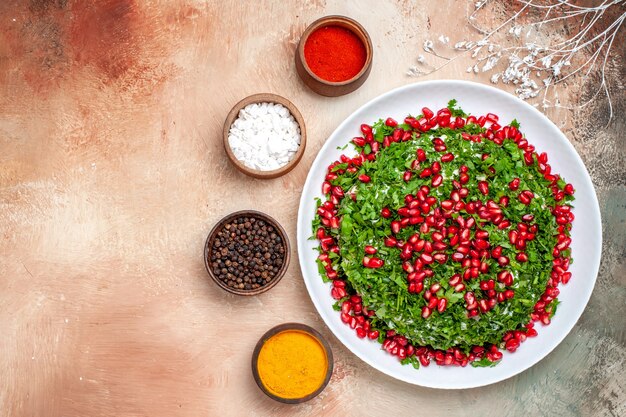 Free photo top view fresh greens with peeled pomegranates on the light table meal fruit color green