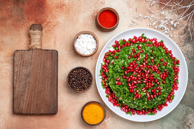 Top view fresh greens with peeled pomegranates on light table meal fruit color greens