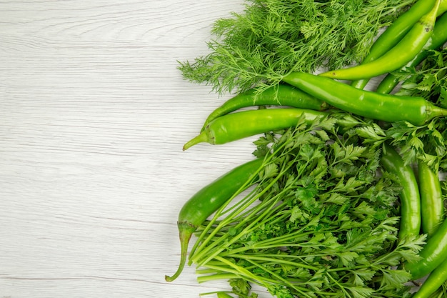 Top view fresh greens with peppers on white background