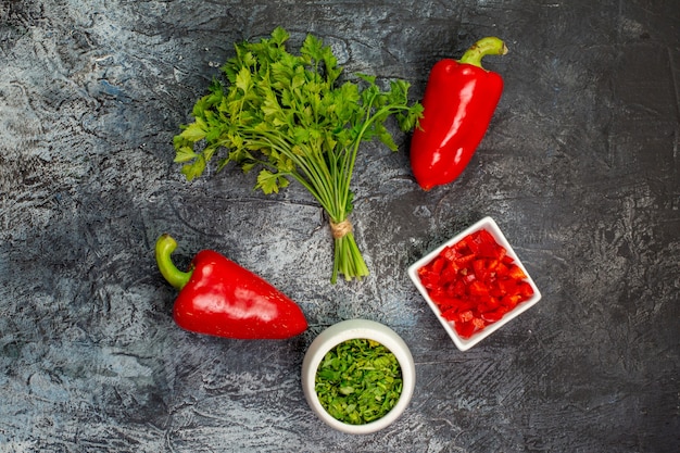 Вид сверху свежей зелени с красным болгарским перцем на светло-сером столе