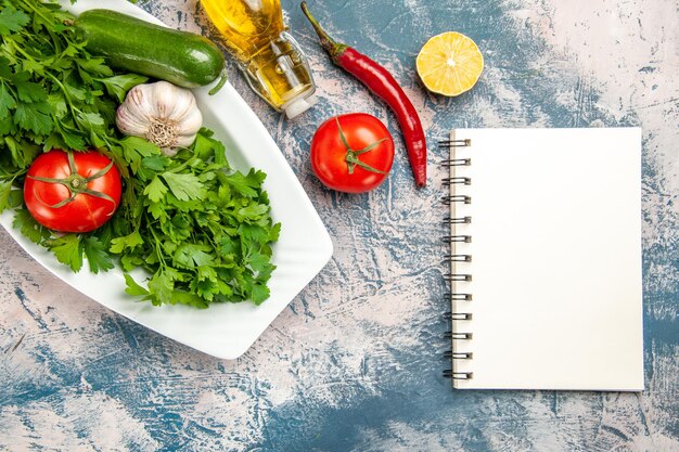 Top view fresh greens with vegetables on a light-blue background