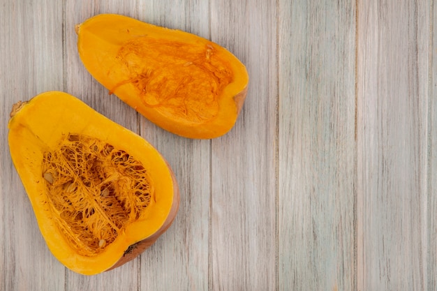 Free photo top view of fresh half pumpkin isolated on a grey wooden wall with copy space