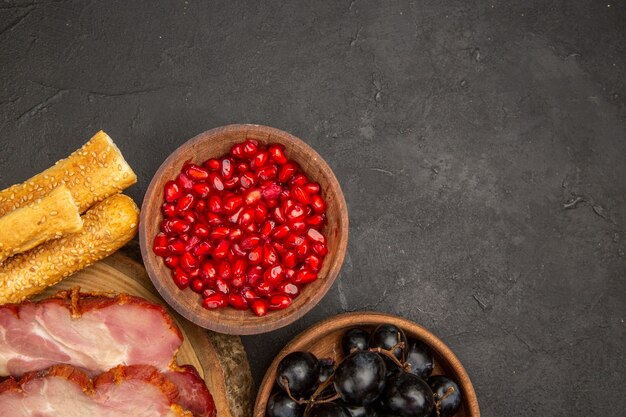 Top view fresh ham slices with fruits on dark background