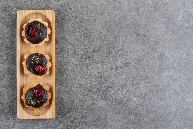 Top view of fresh handmade chocolate cookies on wooden board.