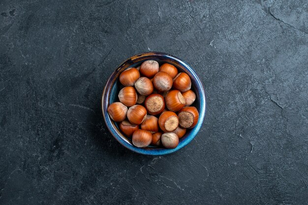 Top view fresh hazelnuts inside little pot on the dark background nut hazelnut walnut snack peanut