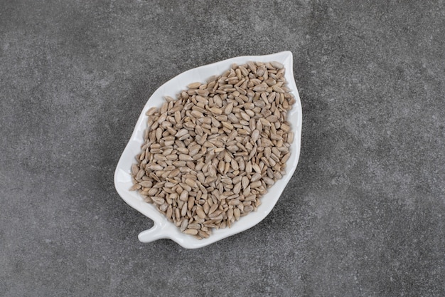 Free photo top view of fresh healthy sunflower seeds on white plate