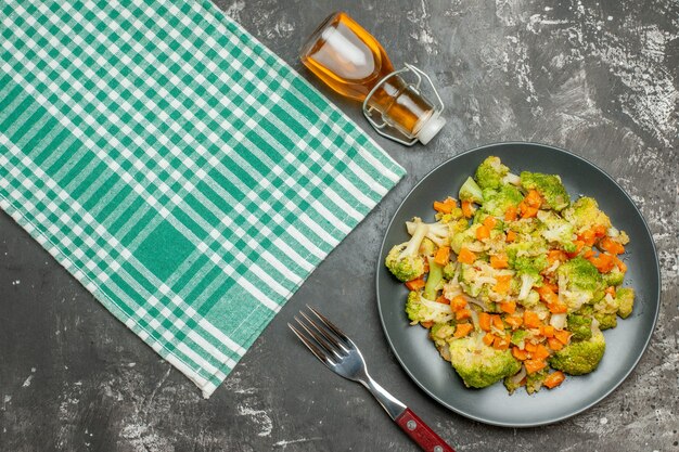 新鮮で健康的な野菜サラダグリーンストリップタオルと落ちたオイルボトルの上面図