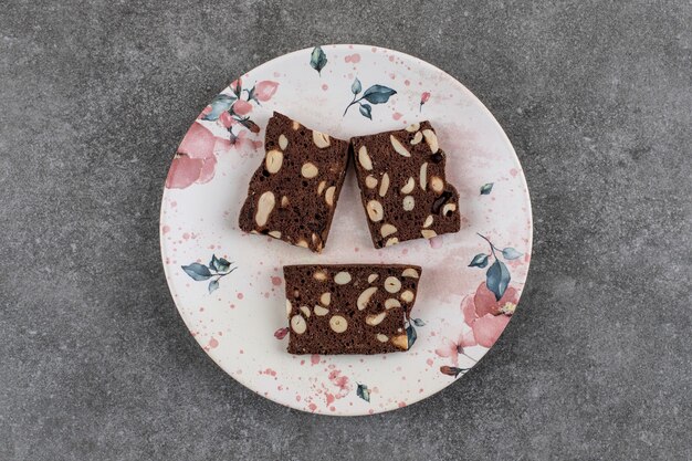 Top view of fresh homemade cake slices on plate over grey surface